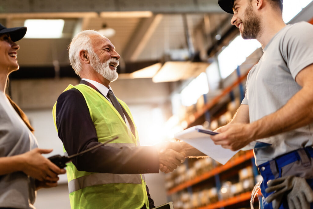 Australian business owner executing a succession plan by transitioning business operations to a younger successor at a trade workshop